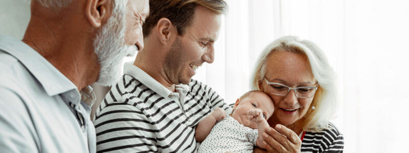 Abuelos, hijo y nieto abrazados