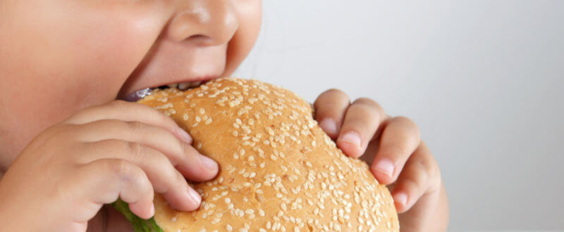 Niño comiendo hamburguesa