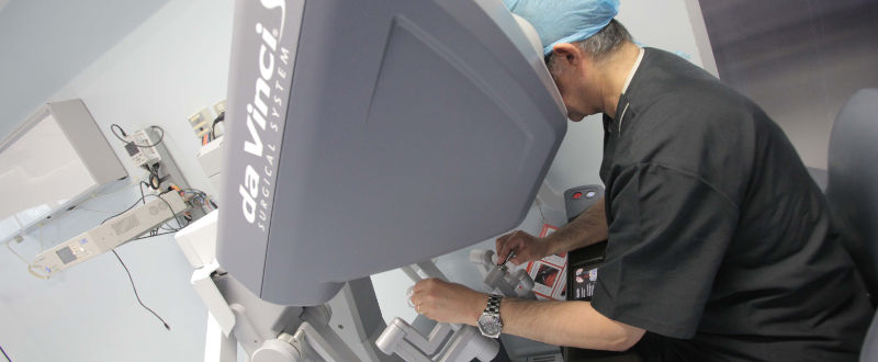 Doctor hace cirugía apoyado de tecnología robótica.