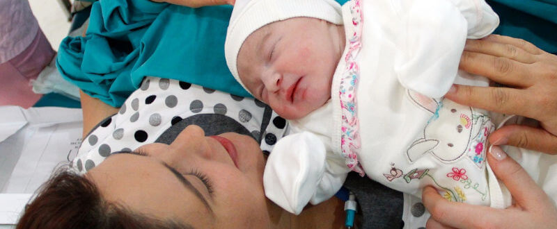 mujer con su recién nacido - tipos de parto