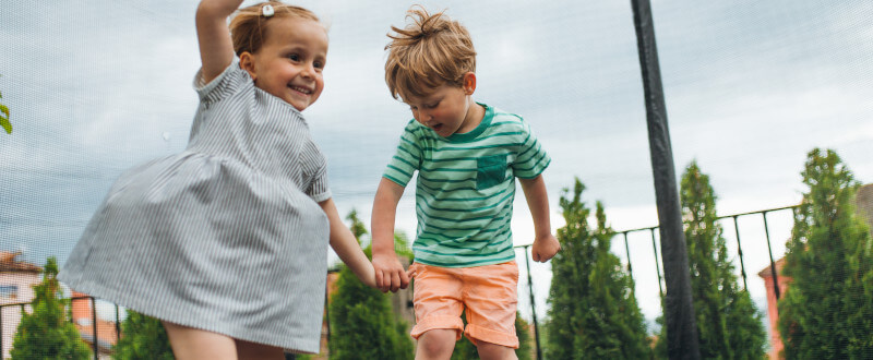 niños saltando en cama elástica