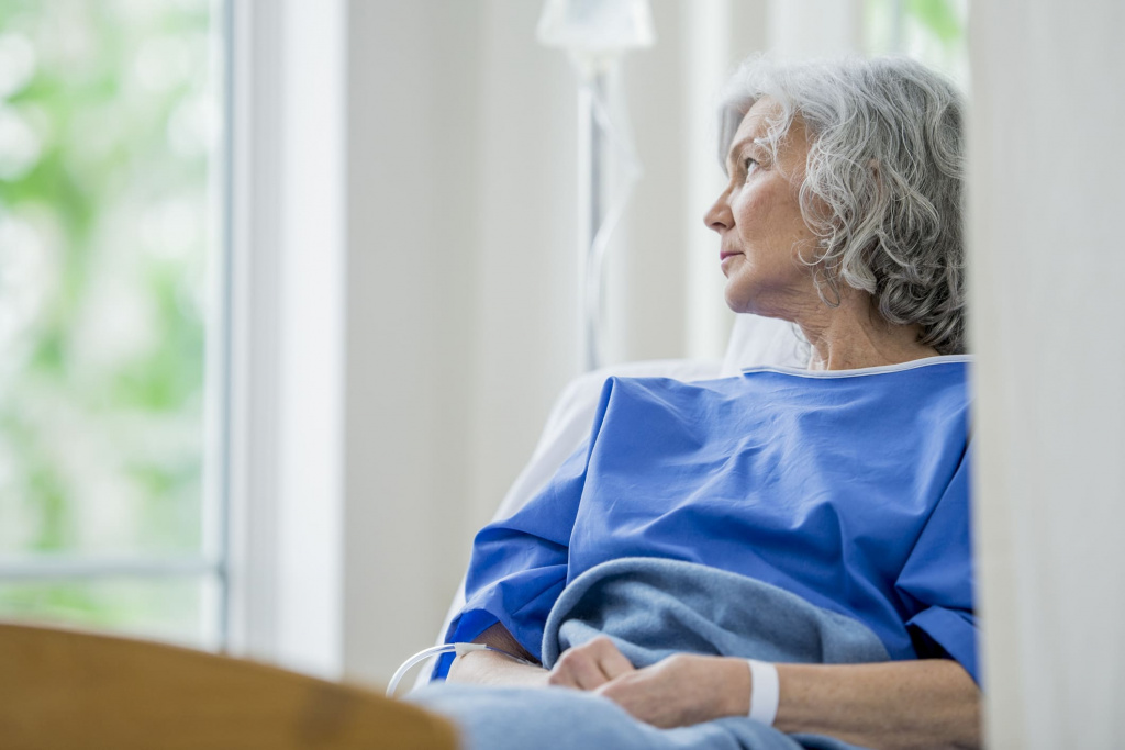 Mujer adulto mayor en hospital mirando por la ventana