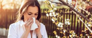 mujer sonándose por alergia