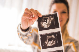 Mujer revisa ecografía de las etapas de su embarazo