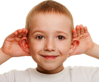Niño tocando sus orejas
