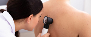 doctora de dermatología examinando espalda de hombre