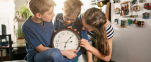 tres niños con un reloj